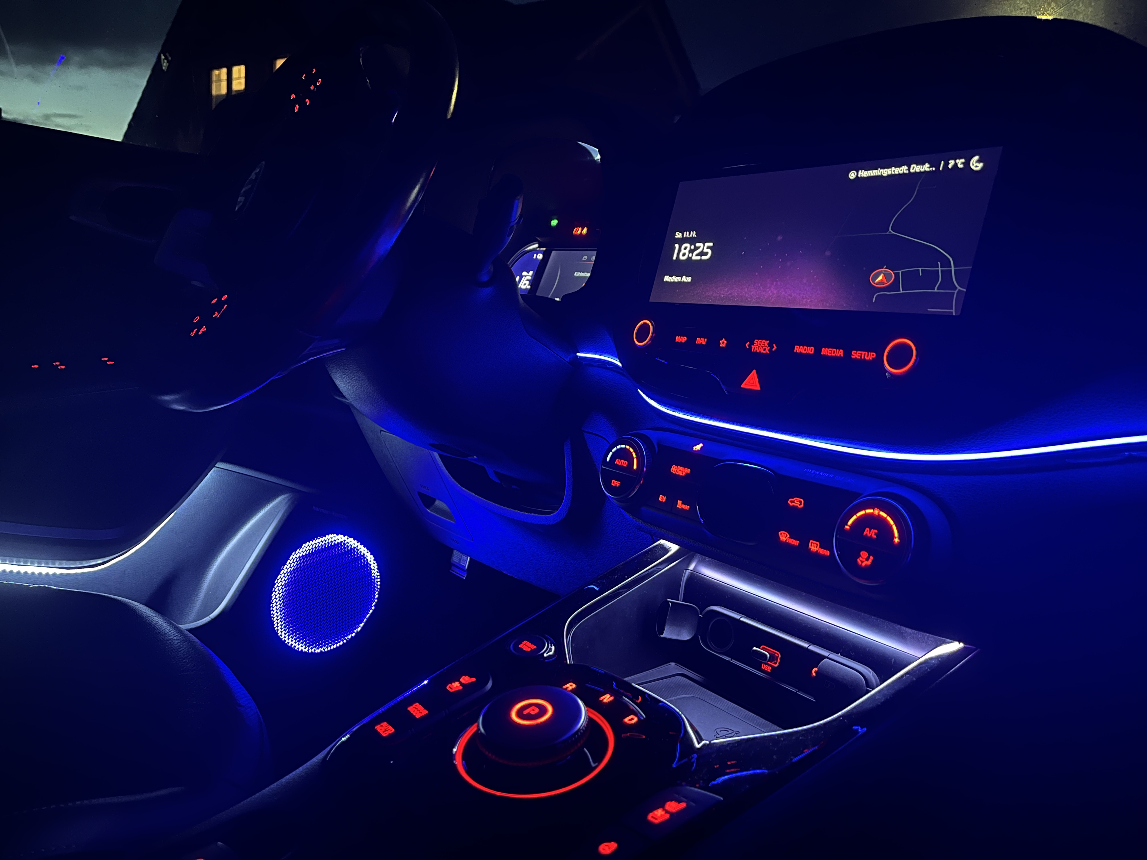 Glowing ambient light strip under the in-car infotainment display
